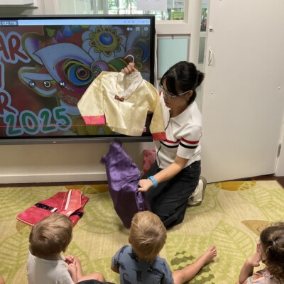 Korean teacher showing her cultural costume for Lunar New Year to Pre-Kindy children